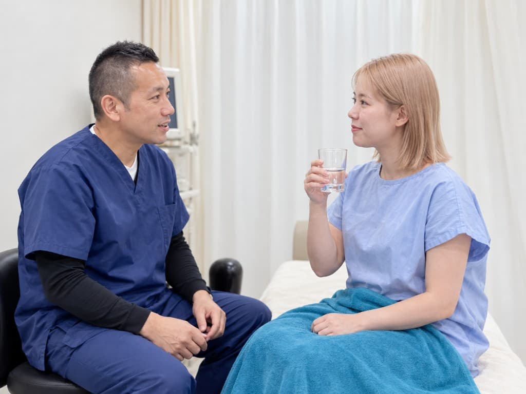 鍼灸院で施術内容を説明する院長と患者さん